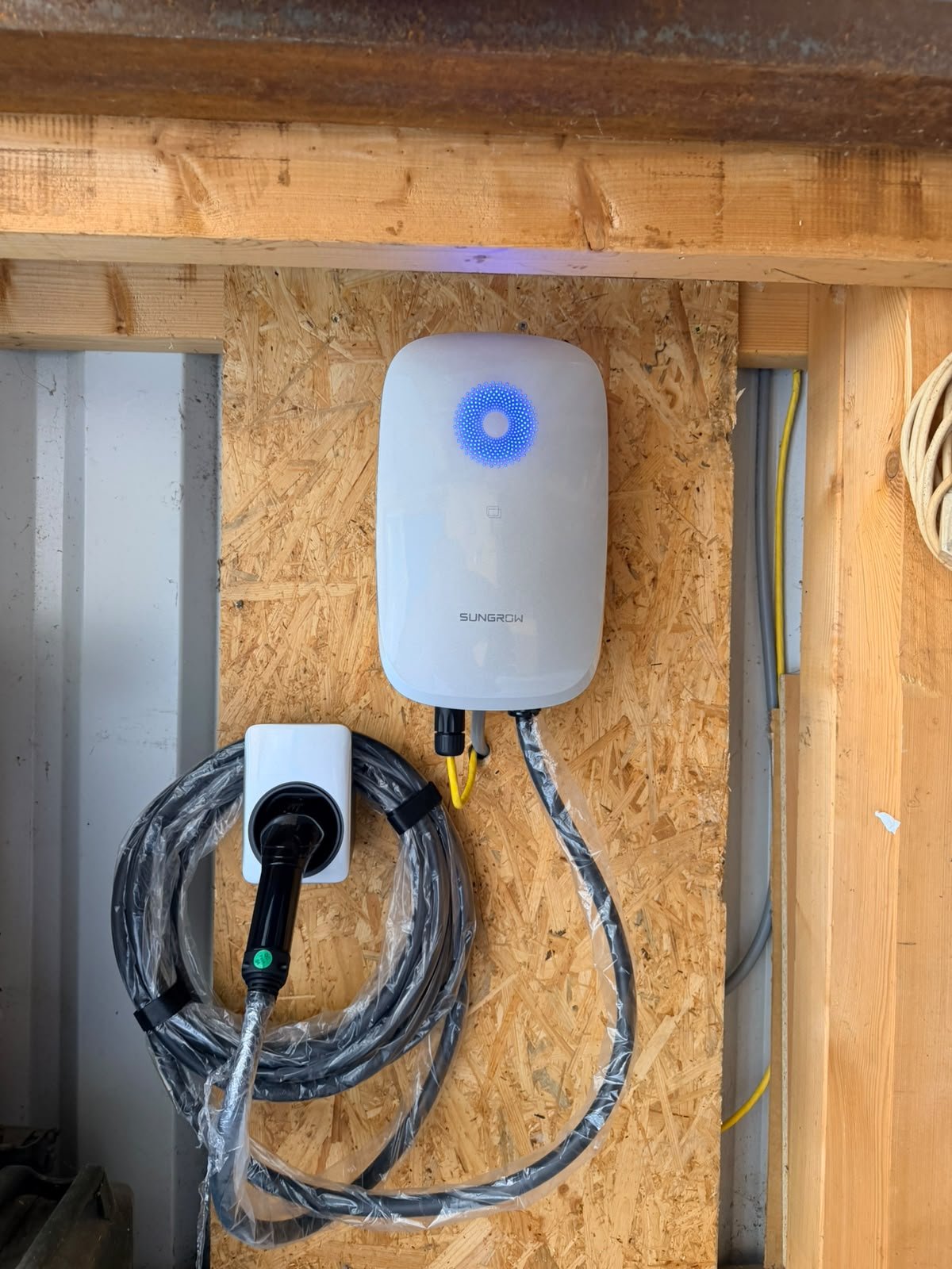 Wallbox montiert, Zuleitung und Ladekabel auf Halterung gelegt